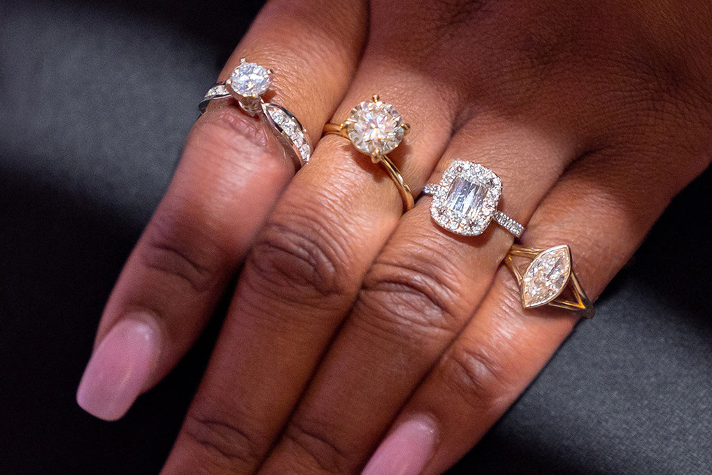 different engagement ring setting examples laid out on models hand