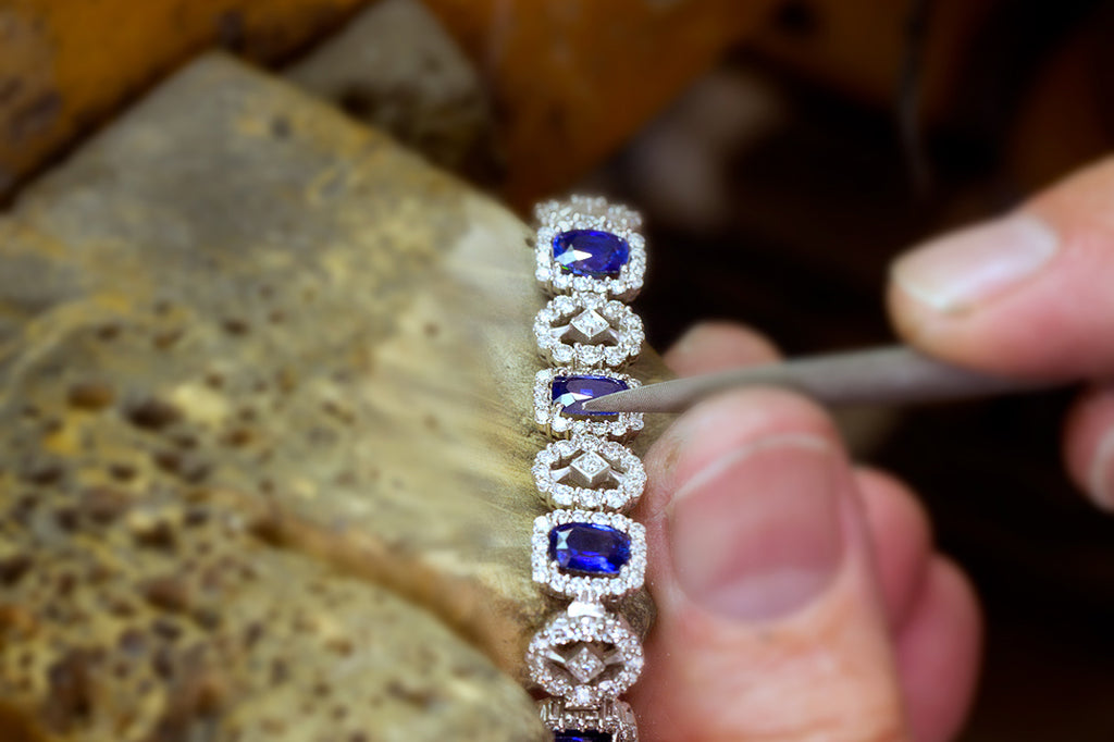 jeweler inspecting stones on custom design bracelet