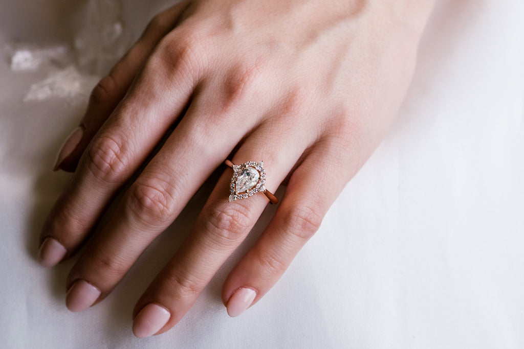 pear diamond engagement ring on models hand