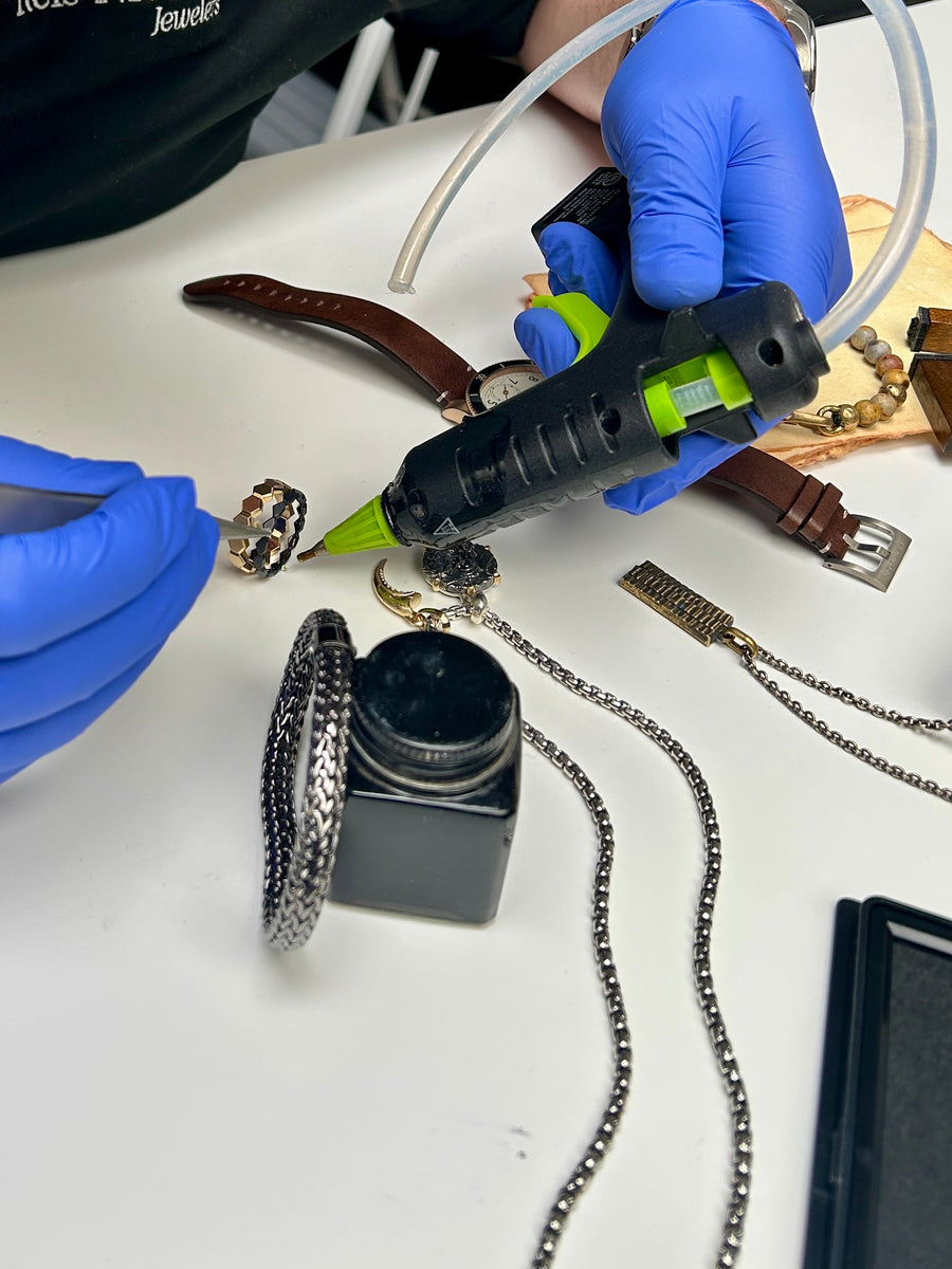 Photo of Reis-Nichols photographer, Michael, hot gluing a David Yurman Hex ring stack to keep it in place while shooting the spring catalog