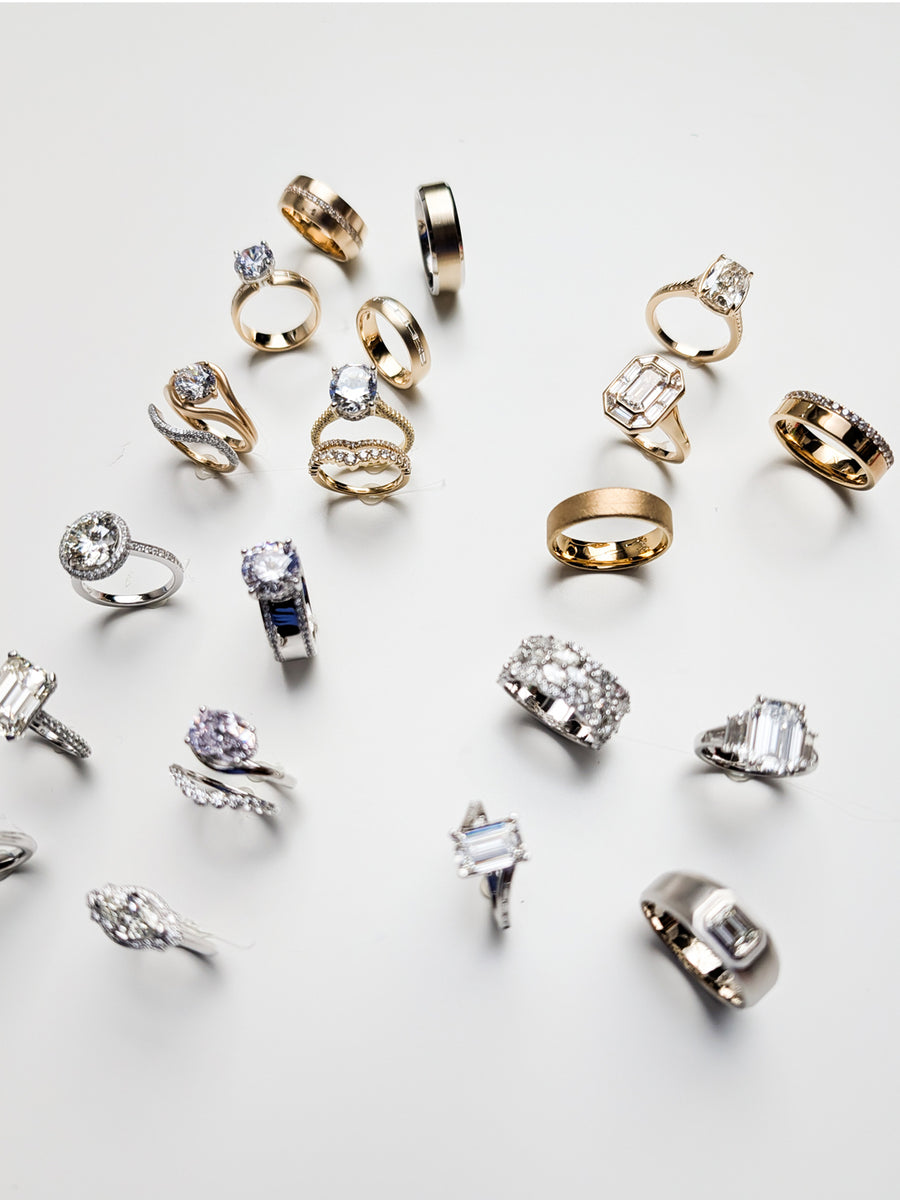 Photo of an assortment of rings hot glued to a table in order for a photographer to shoot the rings from above.