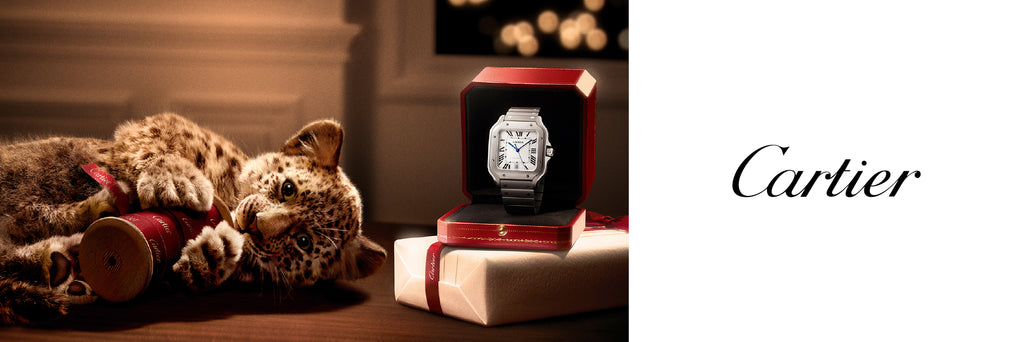 Cartier watch in a box with a stuffed animal on a wooden surface