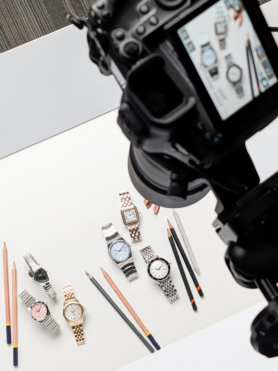 Behind-the-scenes image of a camera shooting the graduation watches spread in the 2026 Reis-Nichols spring catalog.