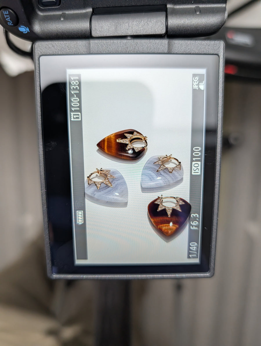 Photo of a camera preview screen showing two pairs of Sorellina guitar pick earrings.